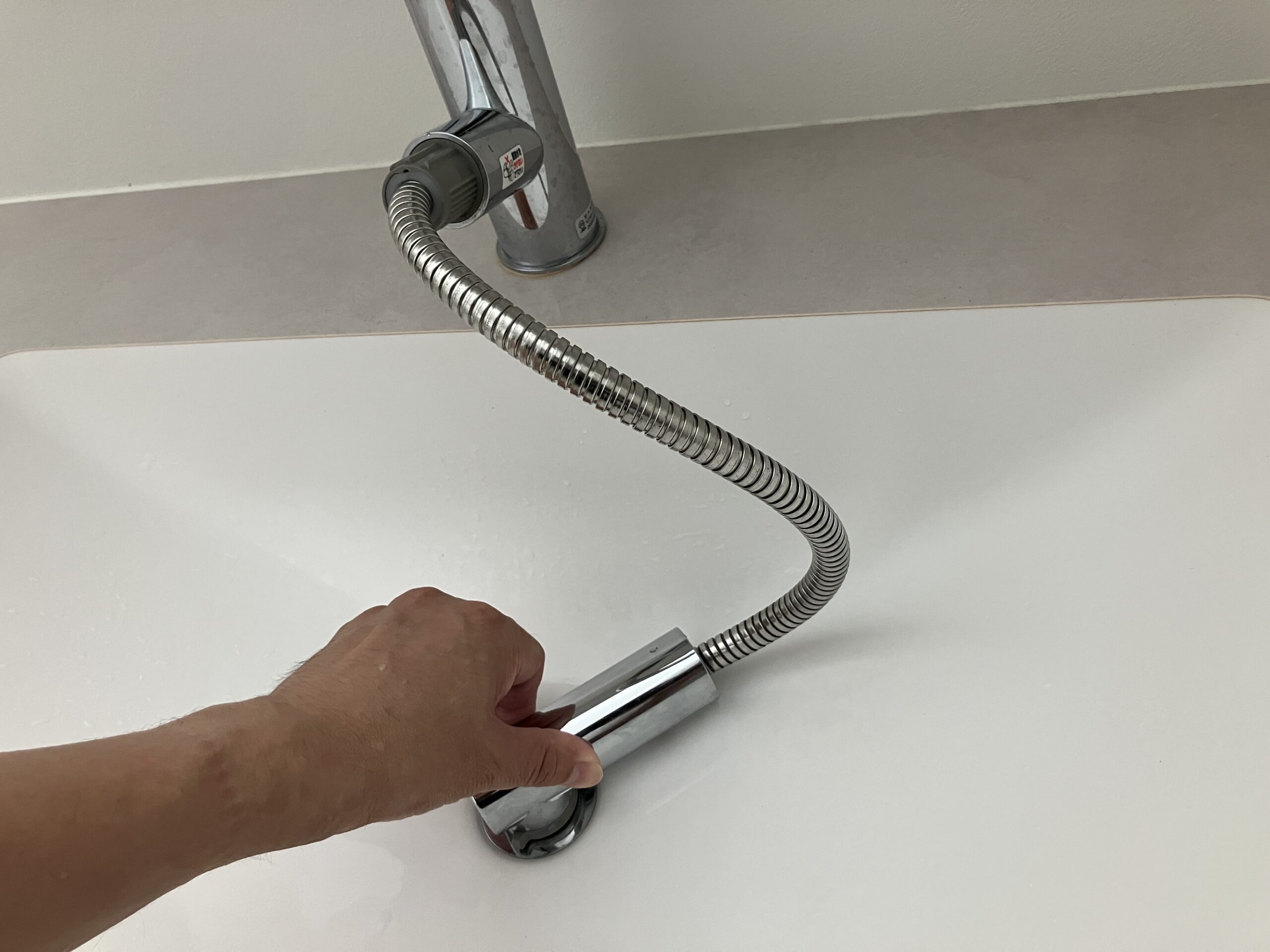 伸びる蛇口を排水口に密着させて水圧をかけている様子