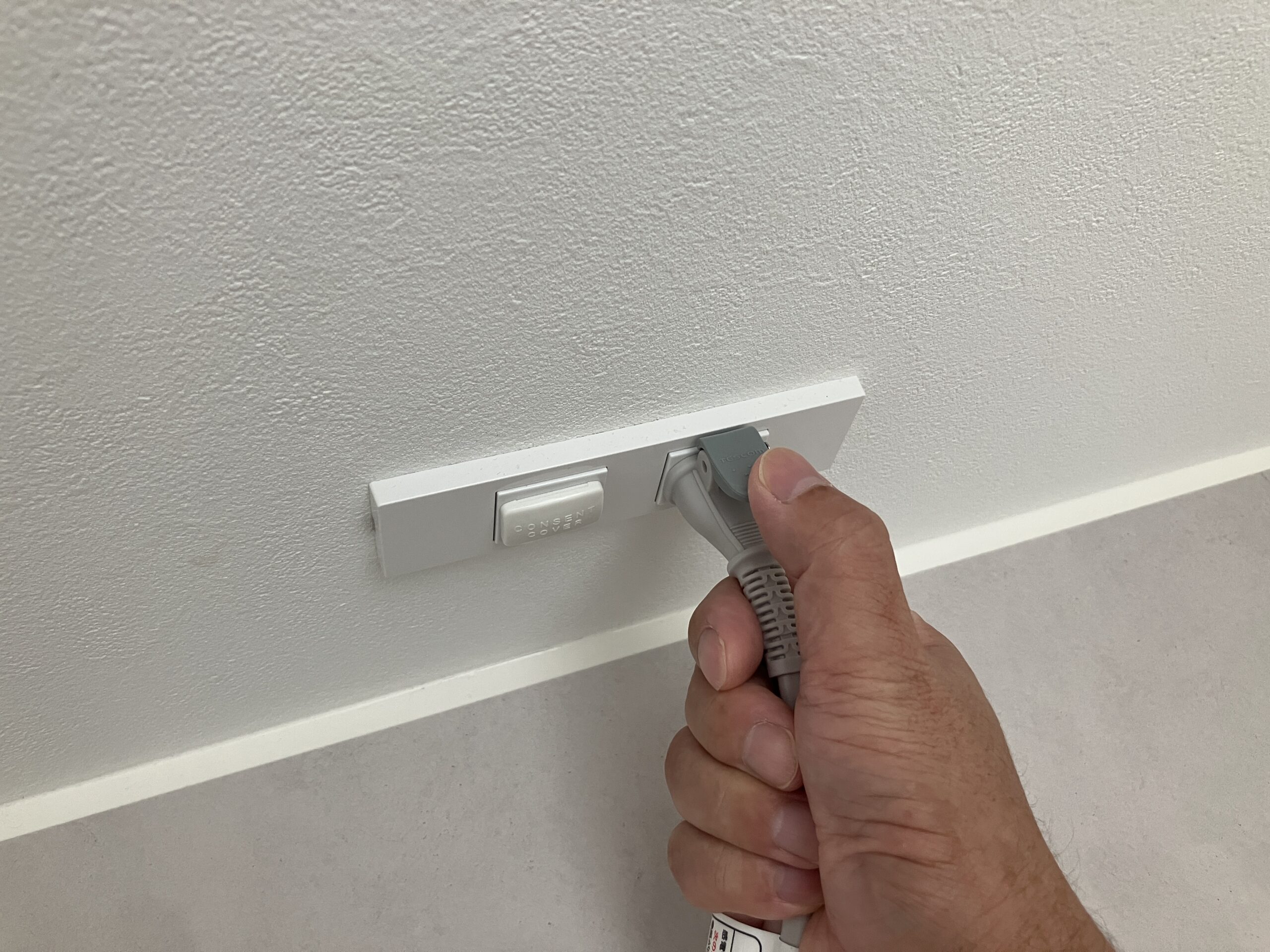 テスコムTD760A-C/Eのラク抜きプラグのボタンを押している手元