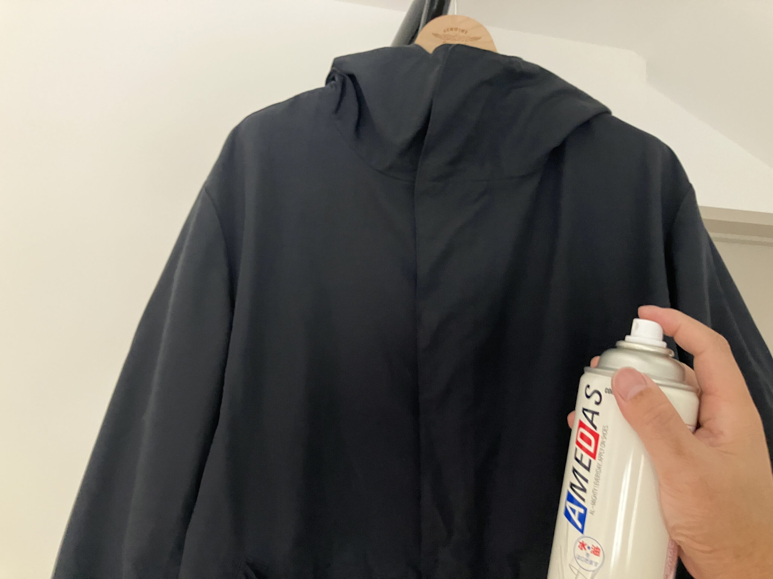 レインコートや傘など水に染みやすいアイテムにアメダス防水スプレーをスプレーしている様子