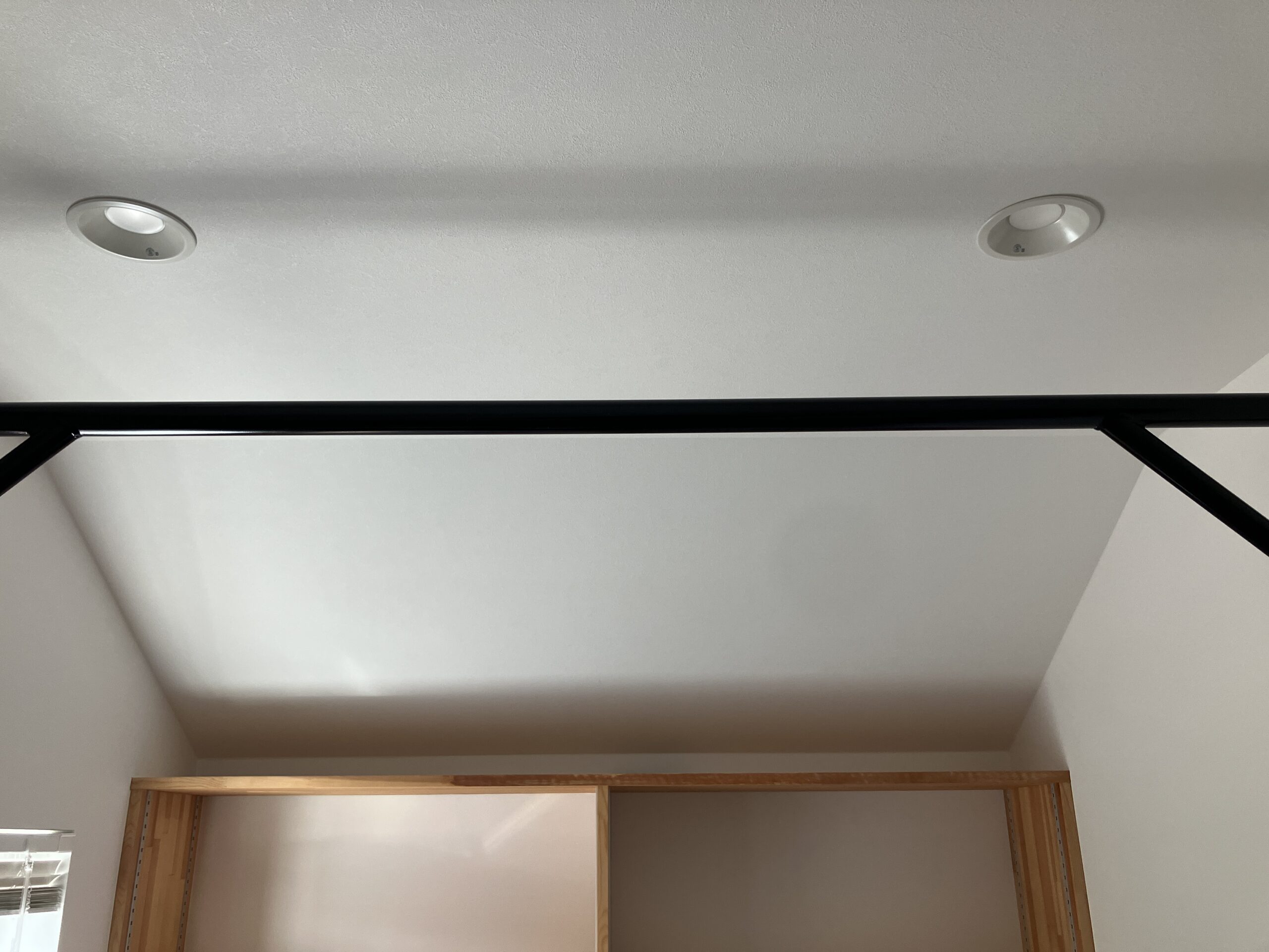 部屋の天井と壁の間に取り付けた、アイアンの懸垂バー全体の写真